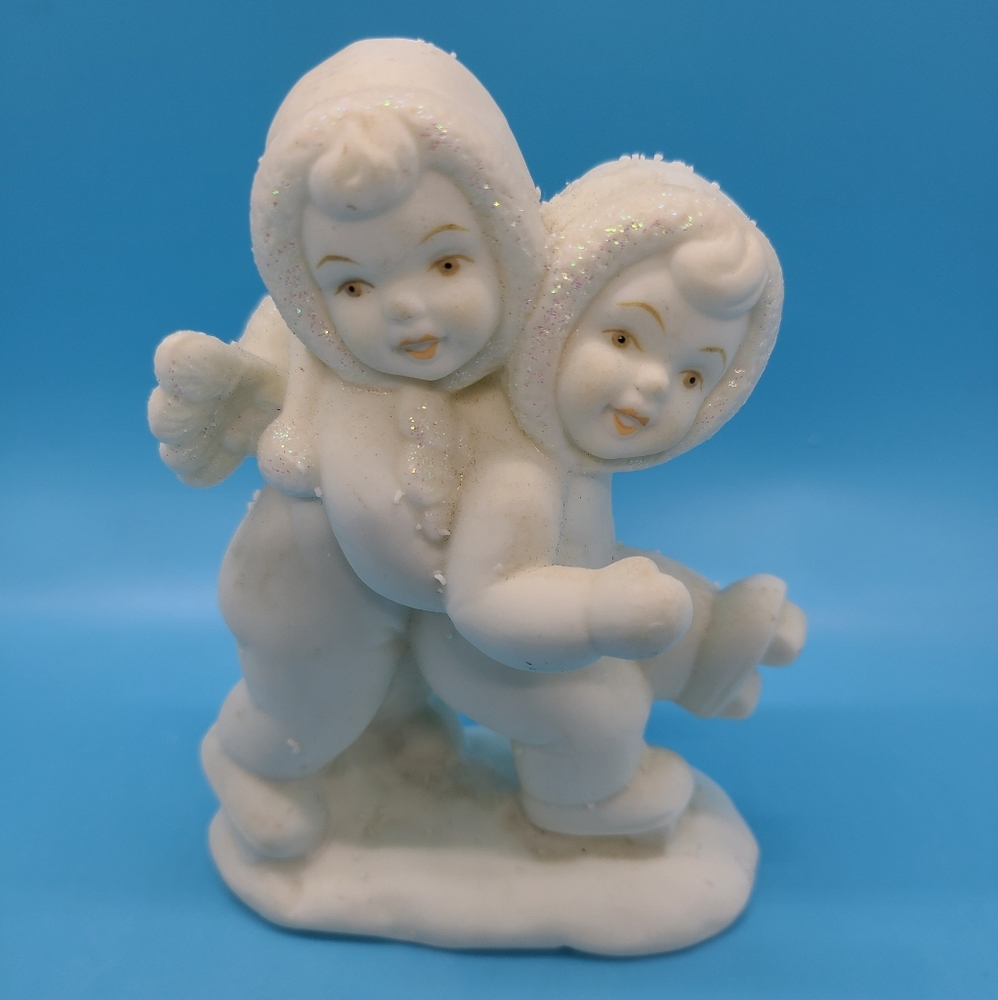 SNOWBABIES FIGURINE OF ANGEL BABY HOLDING UP A SNOWBABY ON SKATES 4" TALL